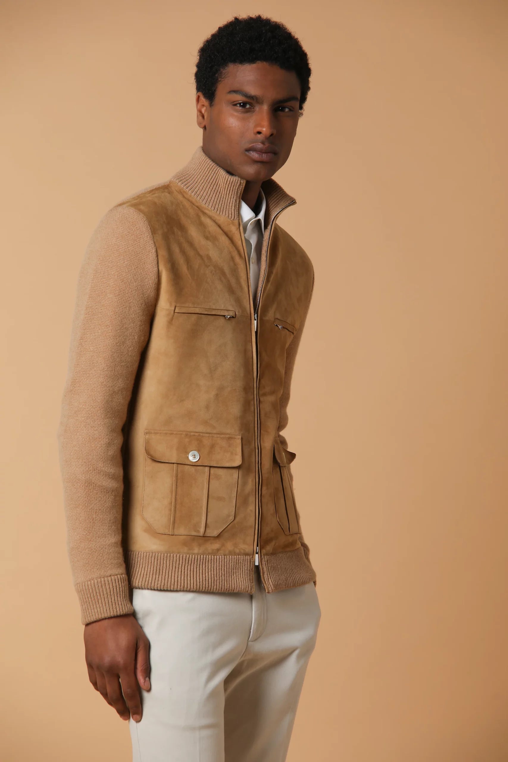 Bomber elegante e sofisticata, realizzata in cashmere con applicazione di suede sul davanti. Contiene 6 tasche ed un doppio cursore. Colore Cammello