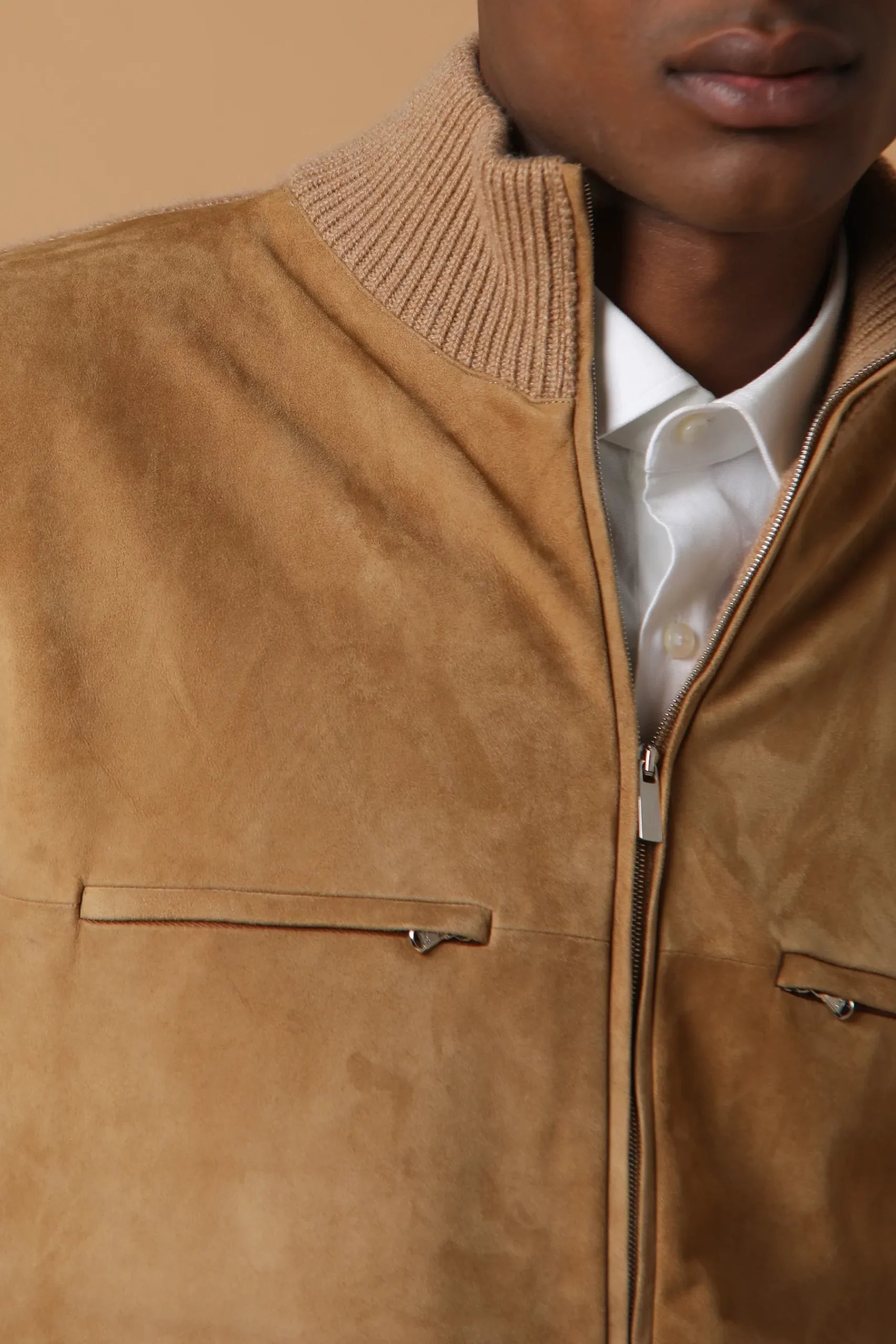 Bomber elegante e sofisticata, realizzata in cashmere con applicazione di suede sul davanti. Contiene 6 tasche ed un doppio cursore. Colore Cammello