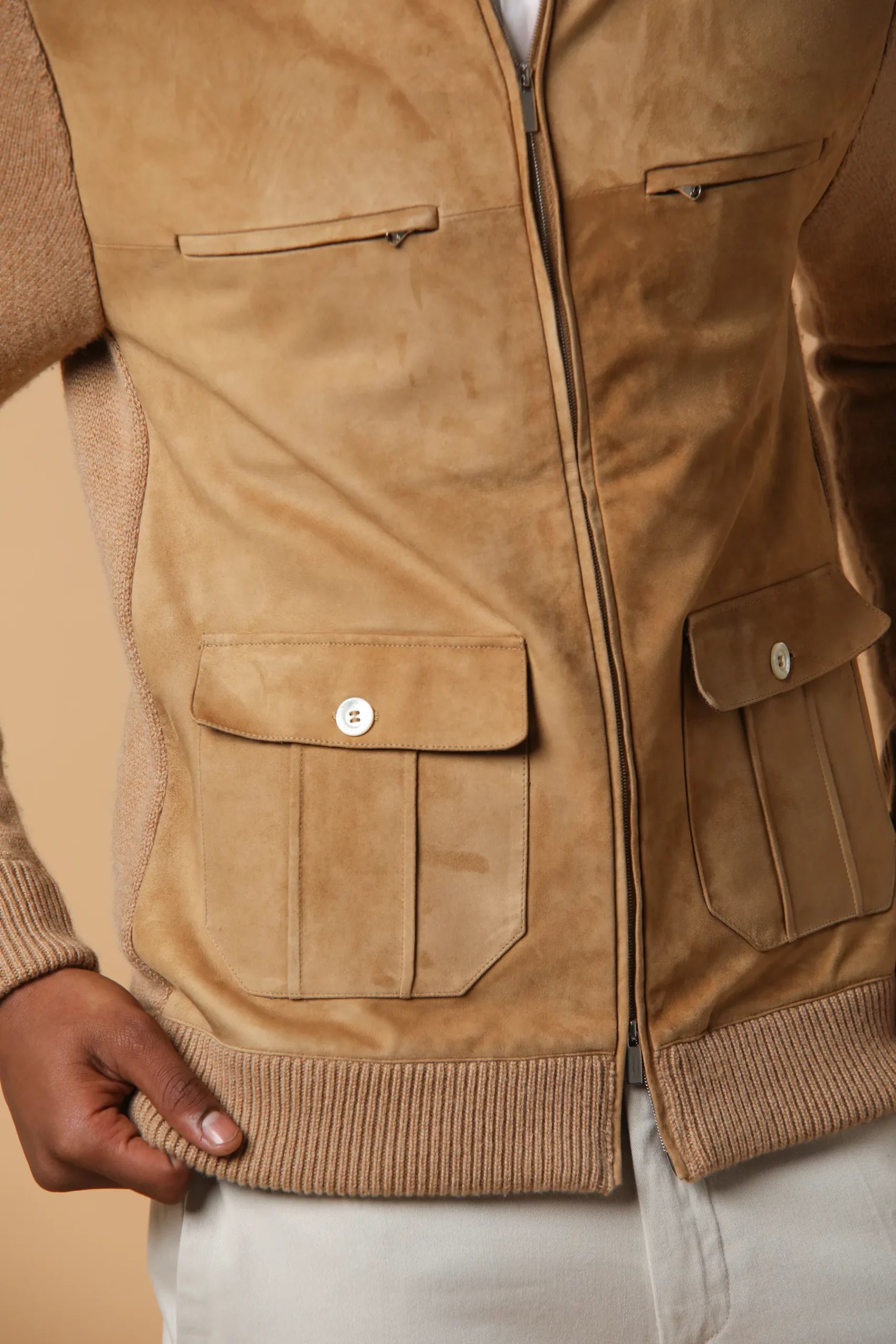 Bomber elegante e sofisticata, realizzata in cashmere con applicazione di suede sul davanti. Contiene 6 tasche ed un doppio cursore. Colore Cammello