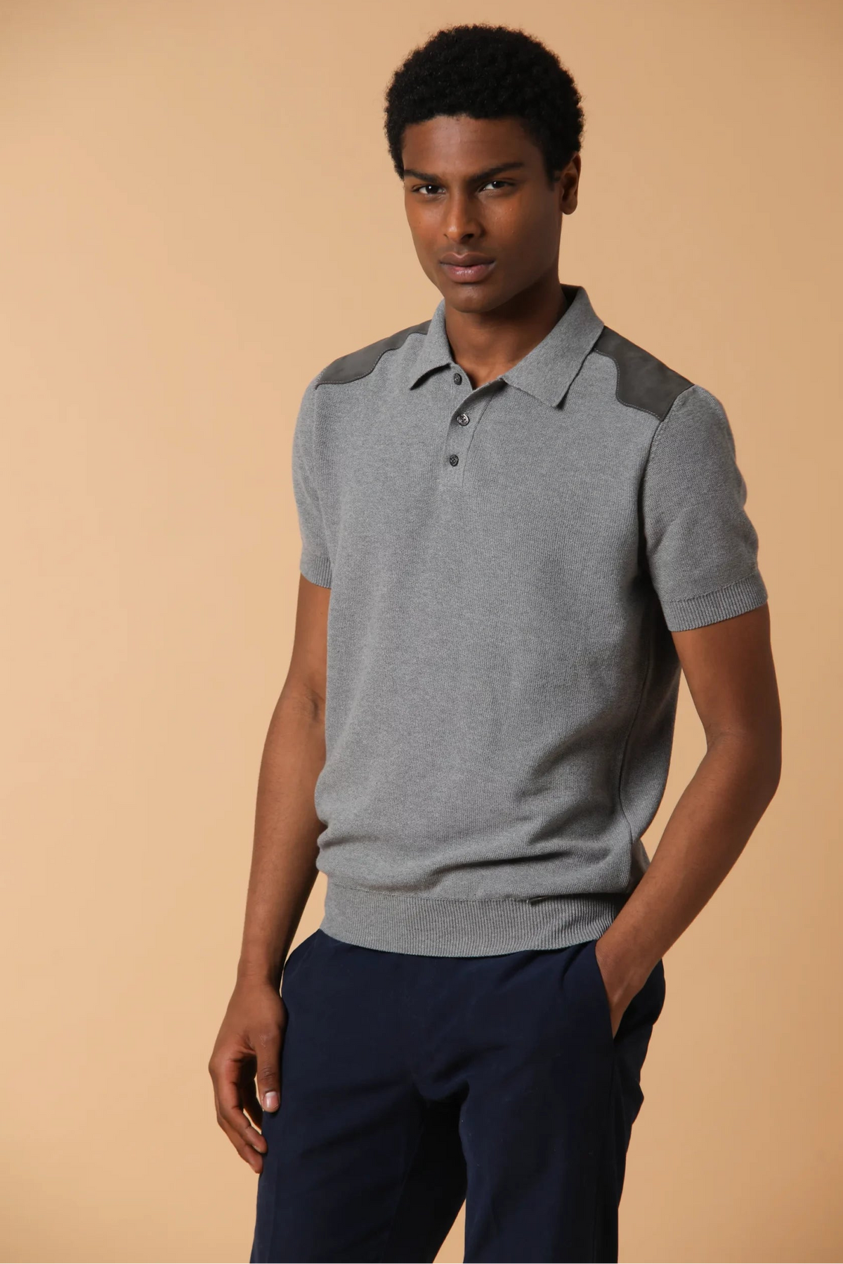 Polo con apertura a tre bottoni realizzata in punto piquet. Presenta applicazioni di suede, che conferiscono un tocco elegante al capo. Colore Grigio.