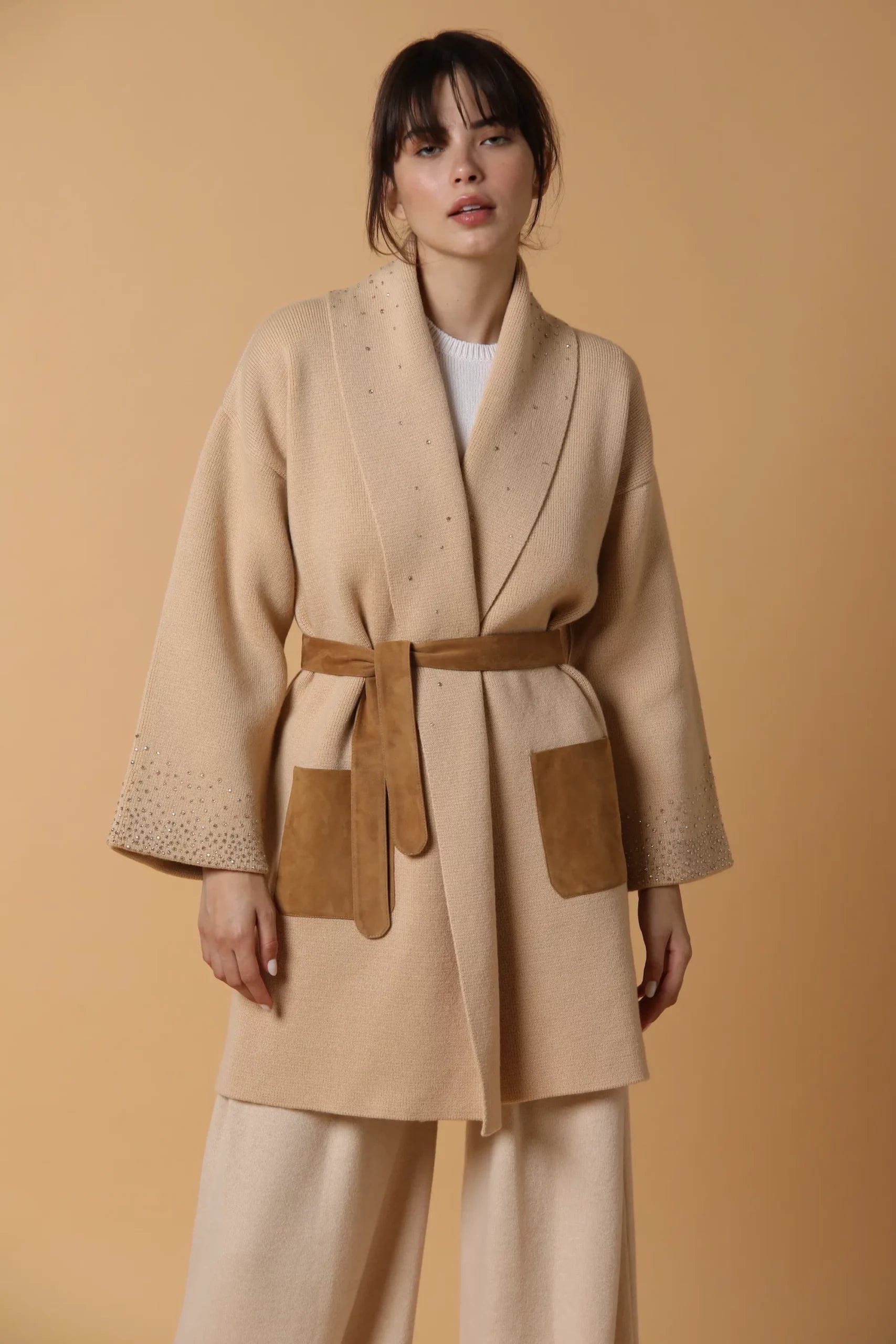 Cappotto in maglia di cashmere, con fodera in seta, tasche in suede ed applicazione di Swarovski. Color cammello.