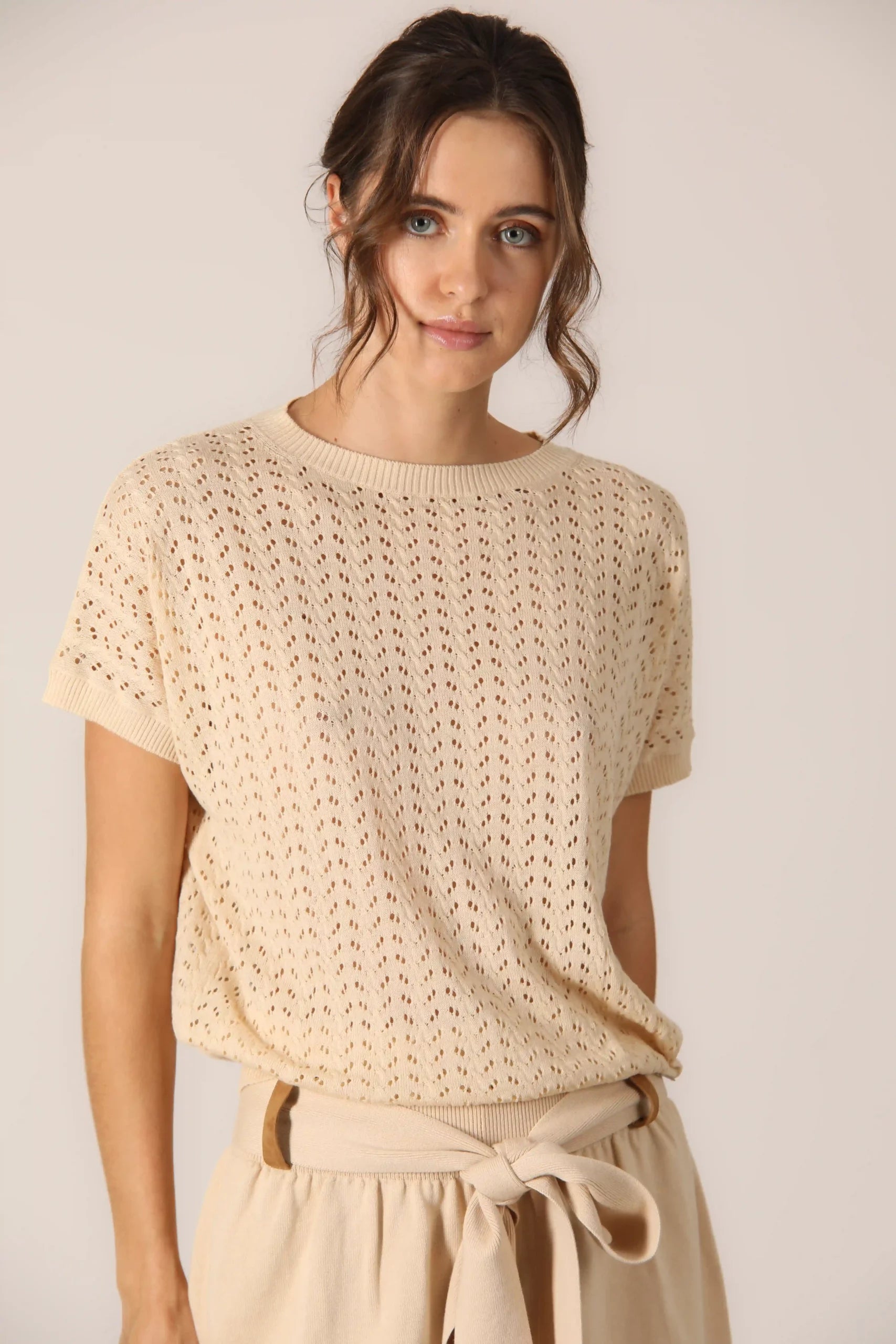 This elegant beige set is perfect for women who want a sophisticated and refined look. The beige knitted top with short open knitted sleeves is made of soft cotton, ensuring comfort and freshness throughout the day.