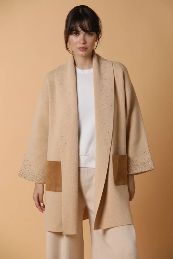 Cappotto in maglia di cashmere, con fodera in seta, tasche in suede ed applicazione di Swarovski. Color cammello.